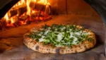Pizza mit Rucola und Parmesan im Pizzaofen